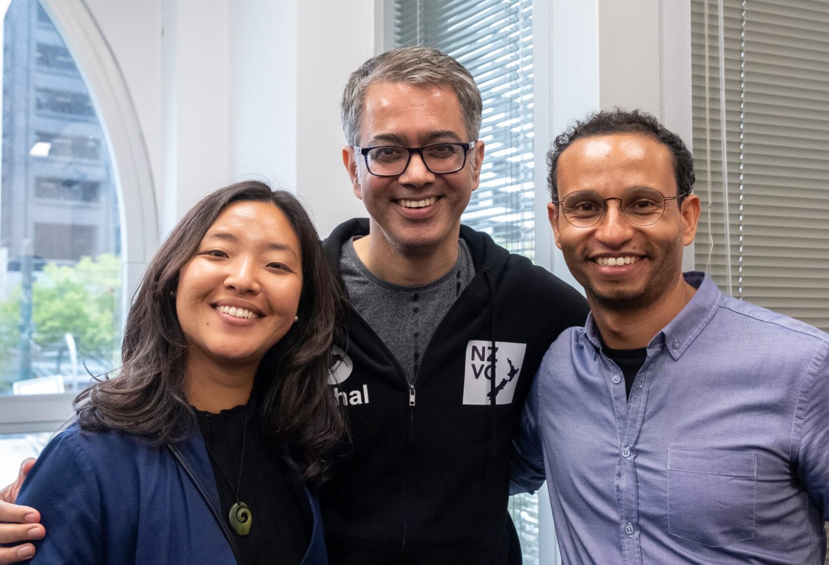 Three attendees, one in an NZVC t-shirt, standing together at Portfolio Day 2022