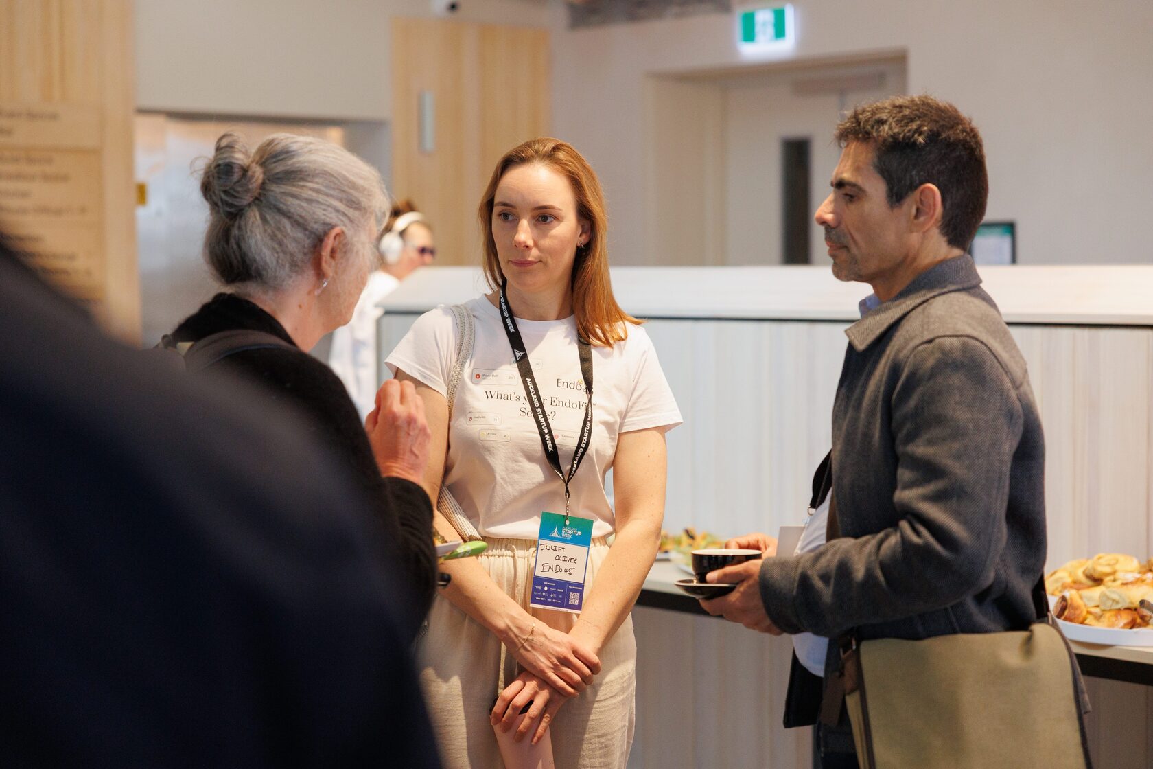 Three attendees talking with plates in hand as Portfolio Day 2025 opens