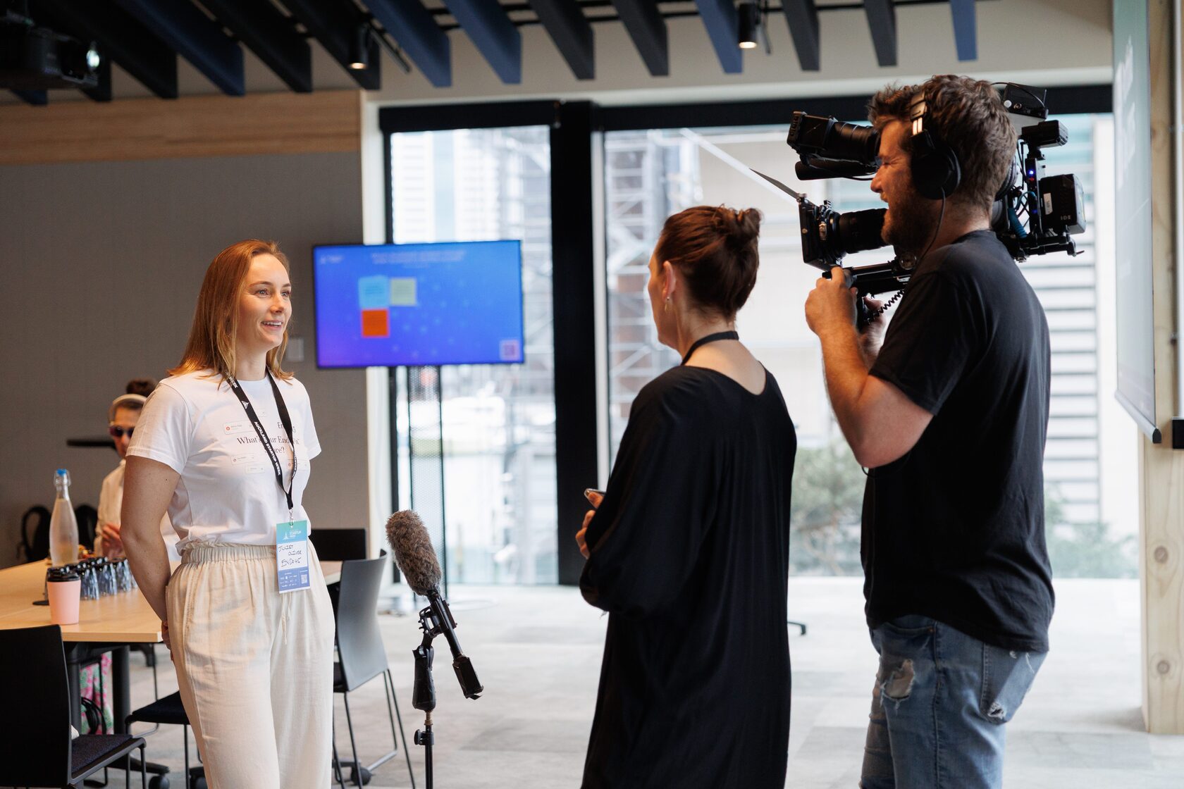 A camera operator filming an interview beside the stage at Portfolio Day 2025
