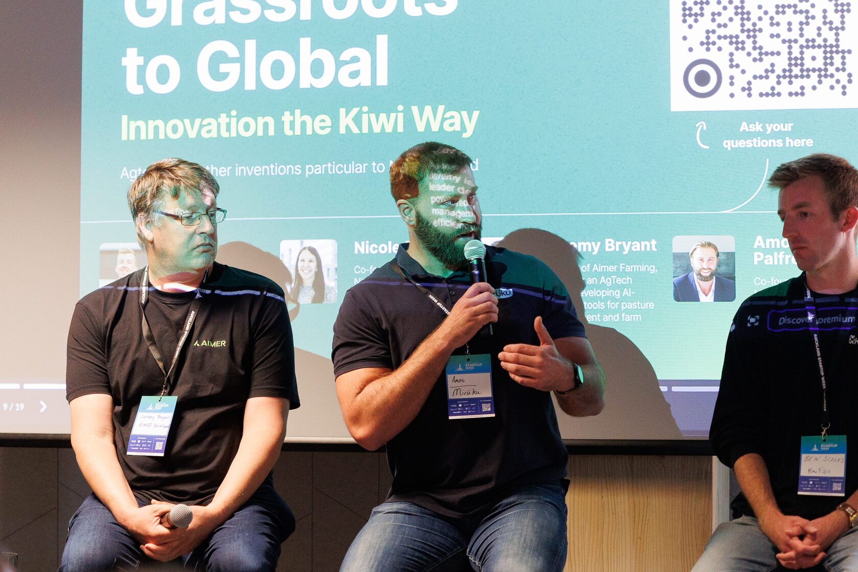 Two panelists on the Grassroots to Global panel, one speaking into a microphone