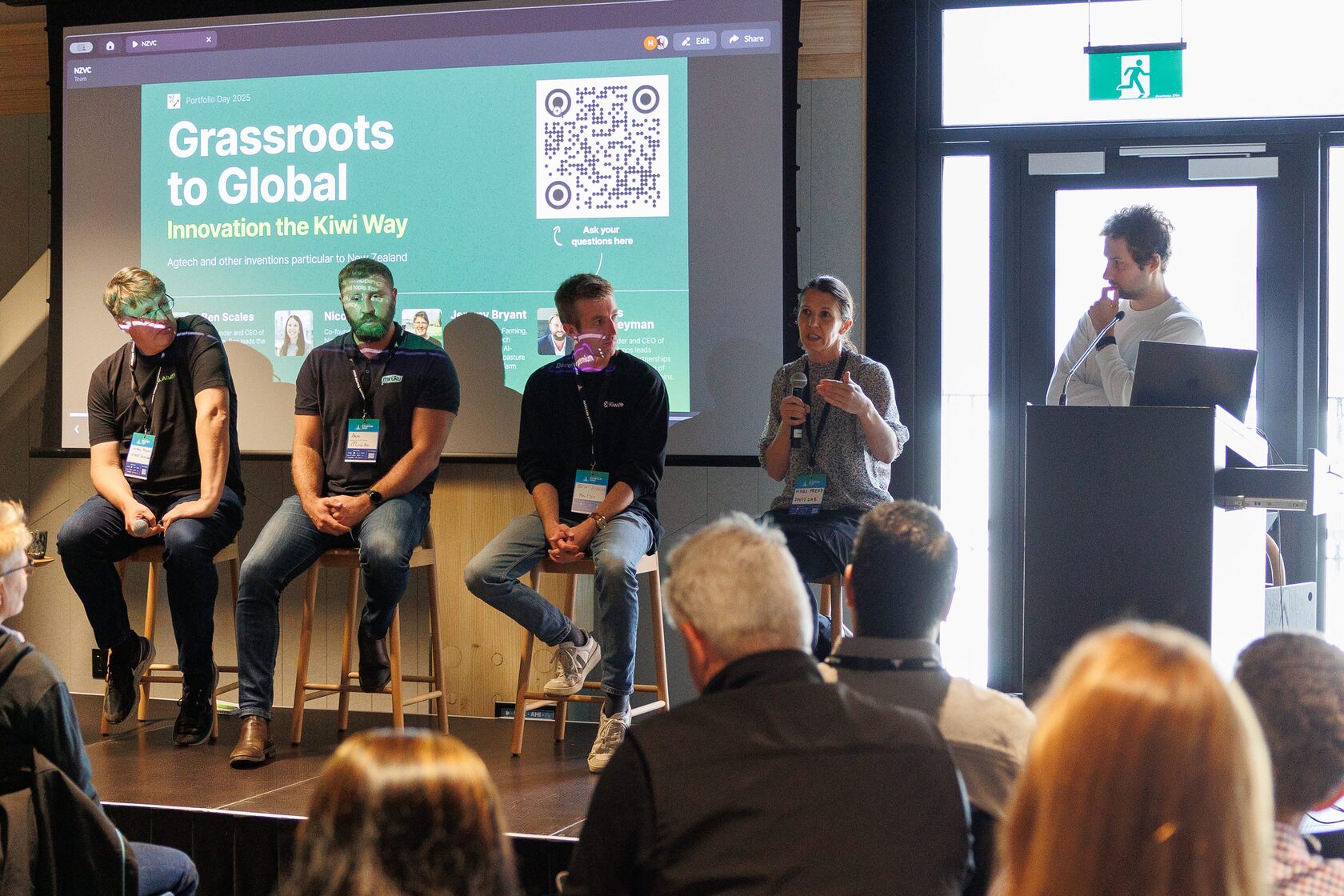 The Grassroots to Global panel seated on stools with the moderator at the lectern