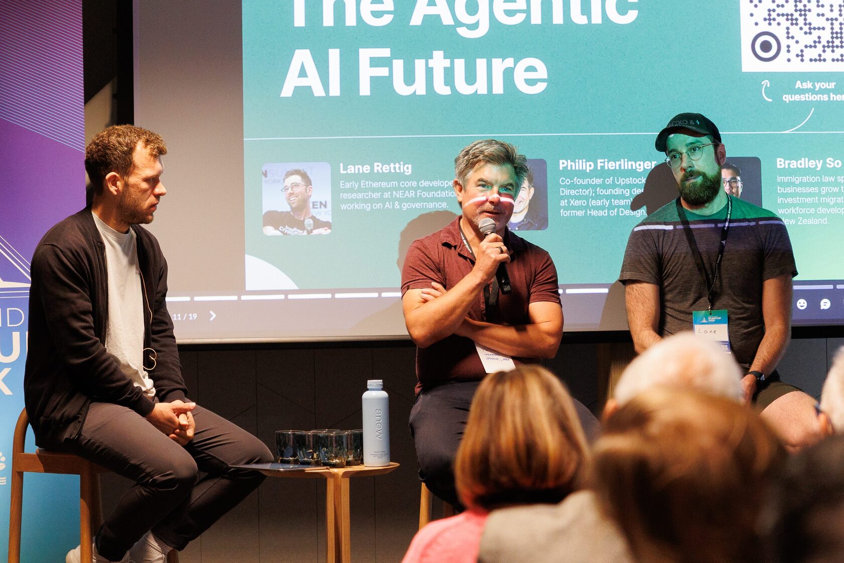 Three panelists under the Agentic AI Future slide, one speaking into a microphone