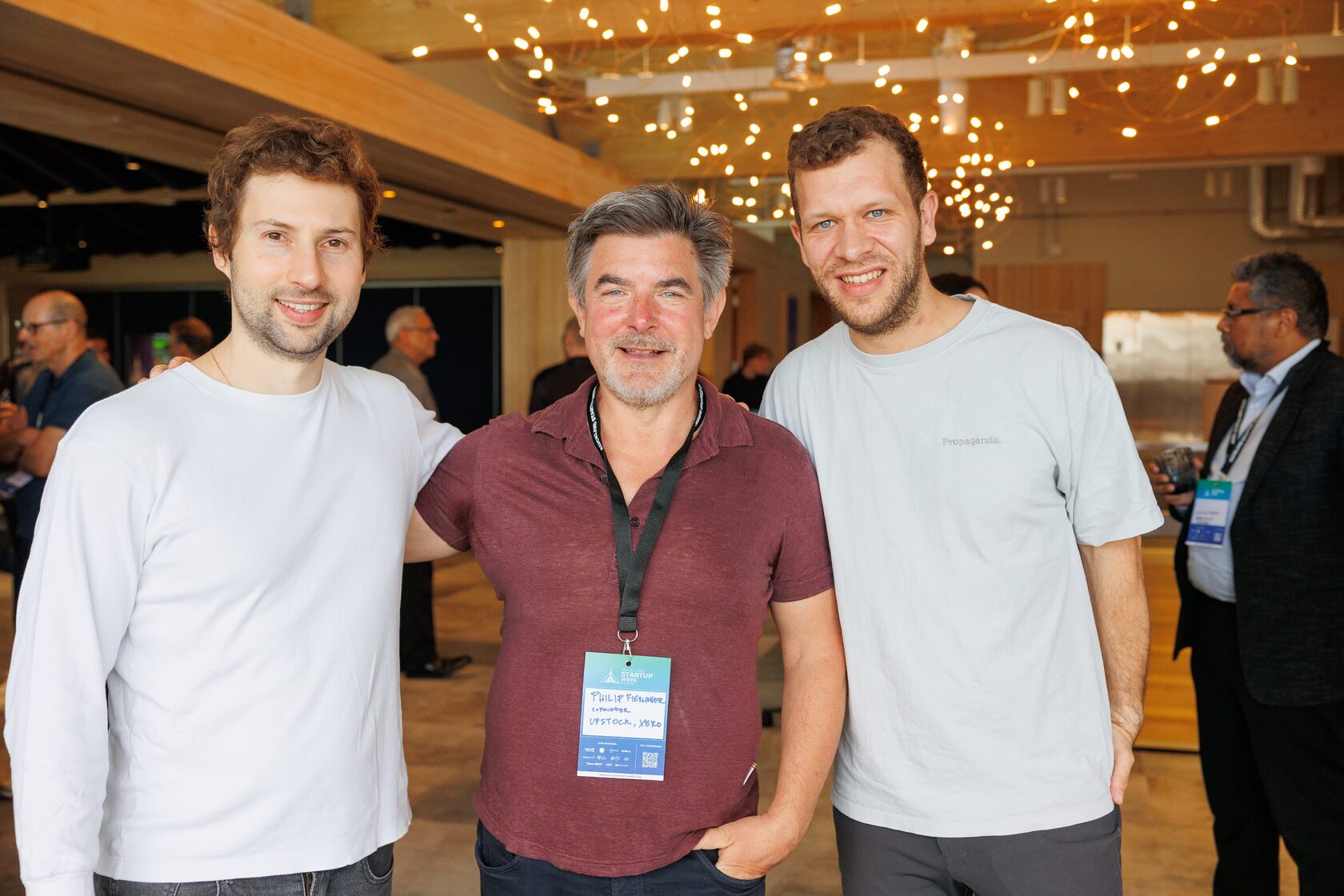 Three attendees standing together during the evening drinks