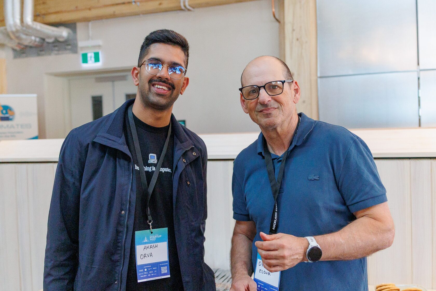 Two attendees standing together beside the registration desk