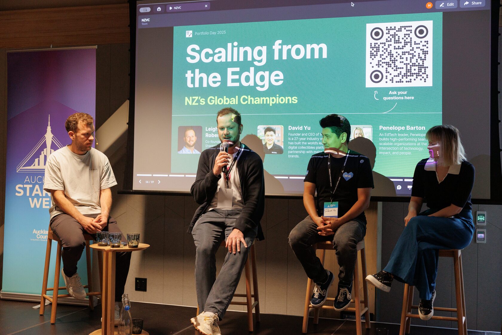 The Scaling from the Edge panel on stage, one panelist speaking into a microphone