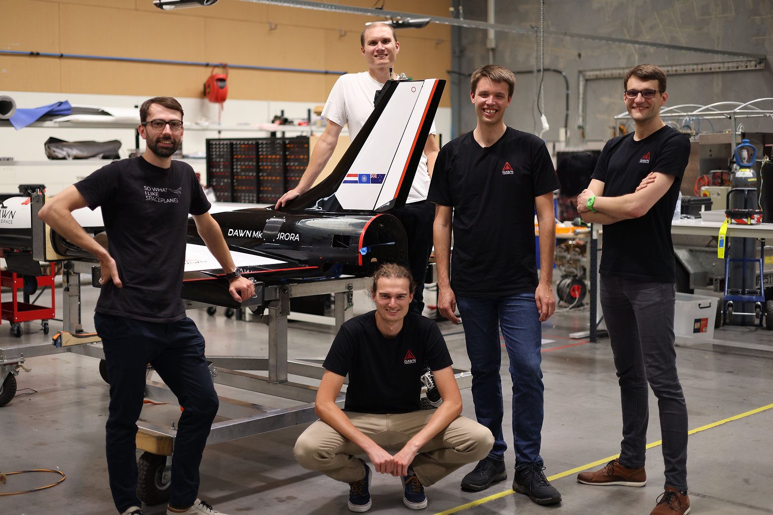 Dawn Aerospace cofounders Stefan Powell, James Powell, Jeroen Wink, Robert Werner and Tobias Knop stand with the Mk-II Aurora in the hangar.