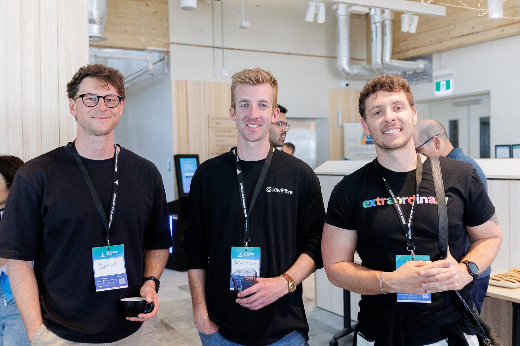 Three founders in company t-shirts, including KiwiFibre and Extraordinary, standing together at NZVC Portfolio Day 2025